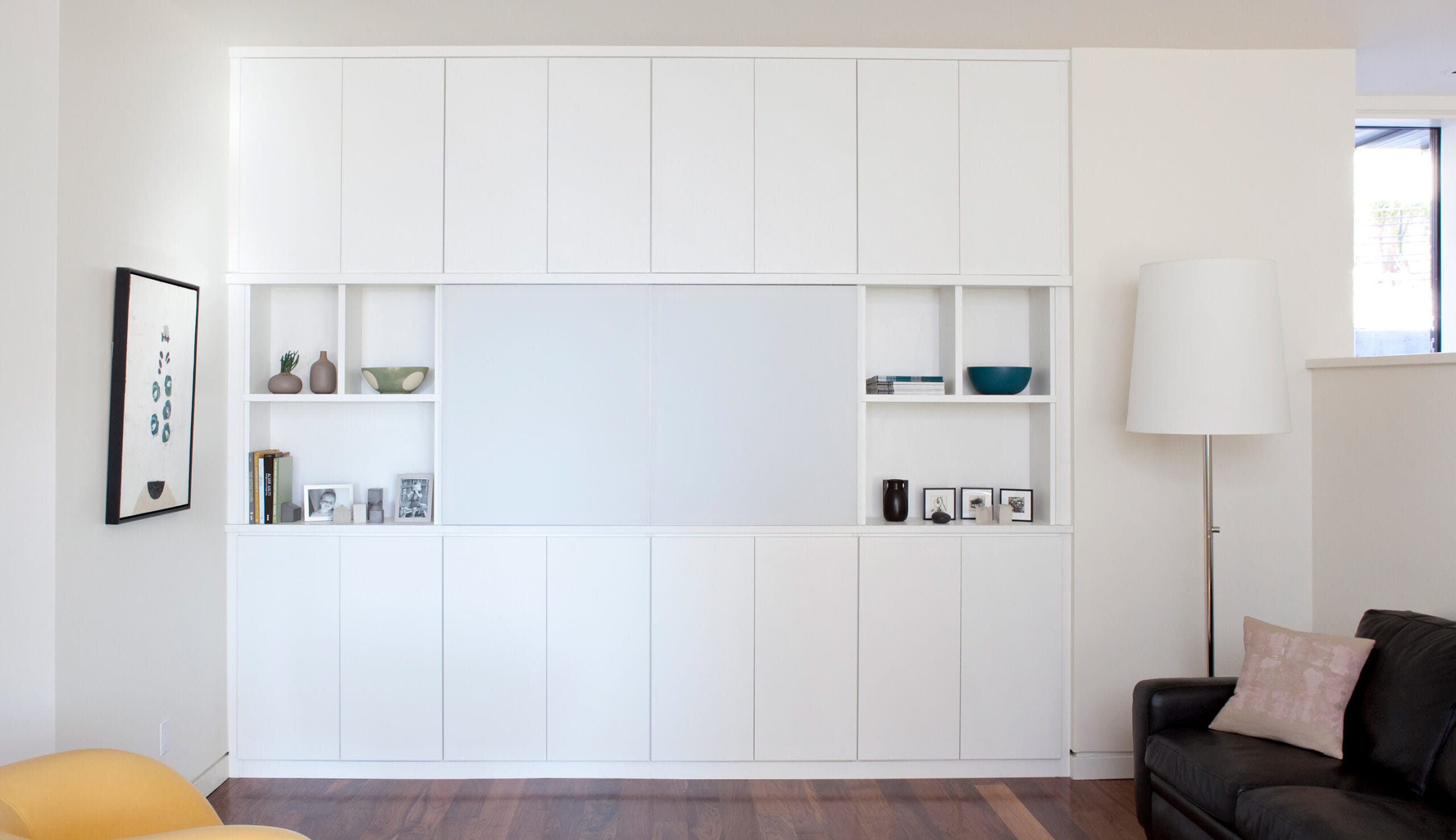 Custom media center with cabinets in a white finish remodeled by California Closets