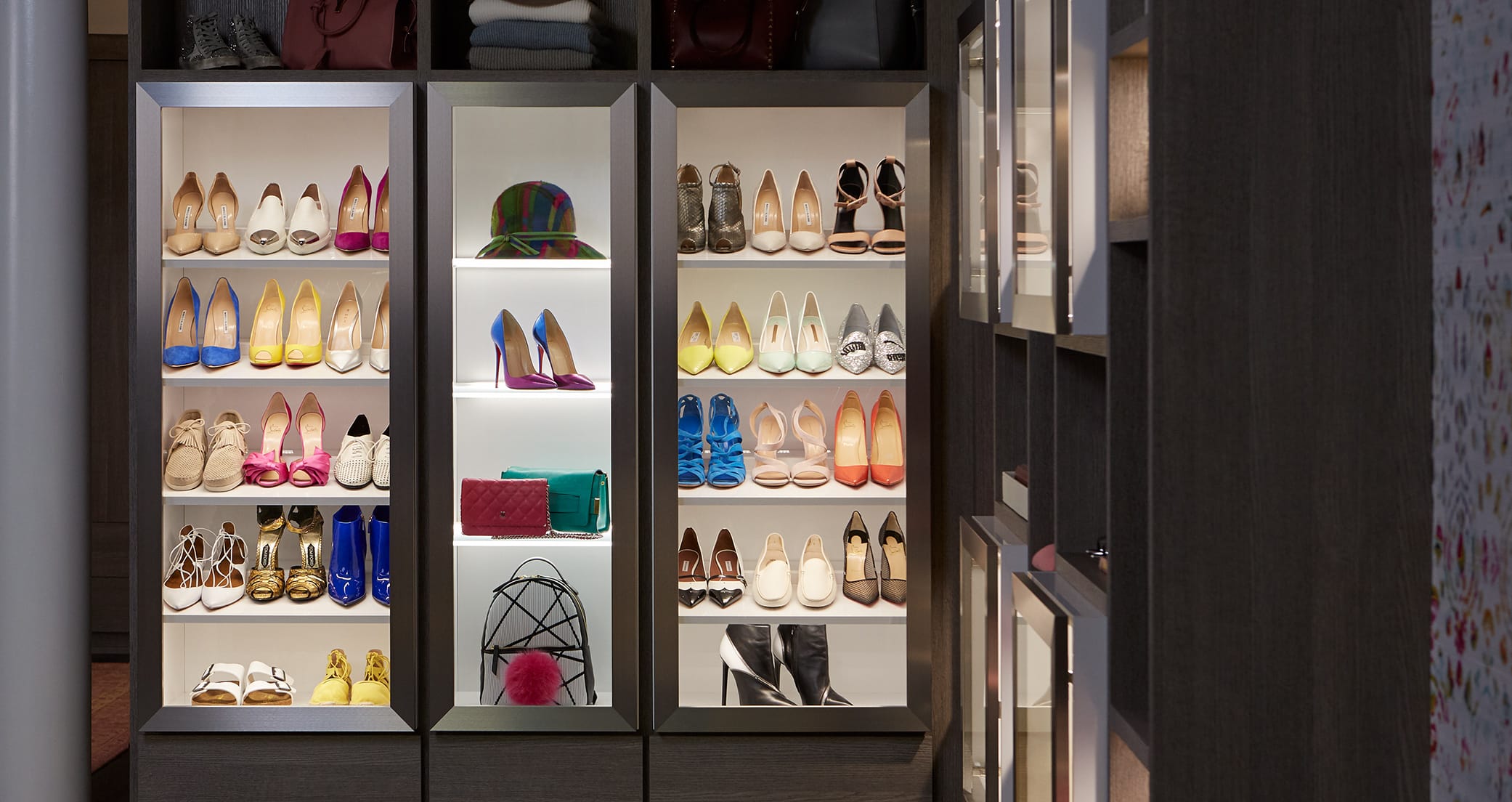 Custom lighting for shoe storage shelving in walk in closet designed by California Closets