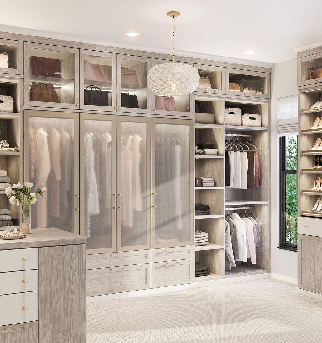Walk-in closet featuring light grain finish, see-through wardrobe doors, and built-in shelving by California Closets