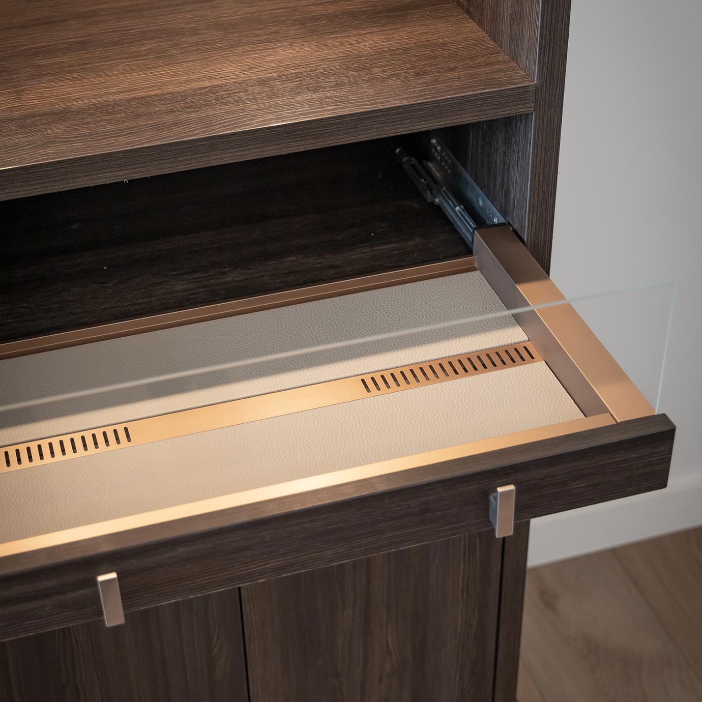 Custom drawer in a dark wood finish with leather by California Closets