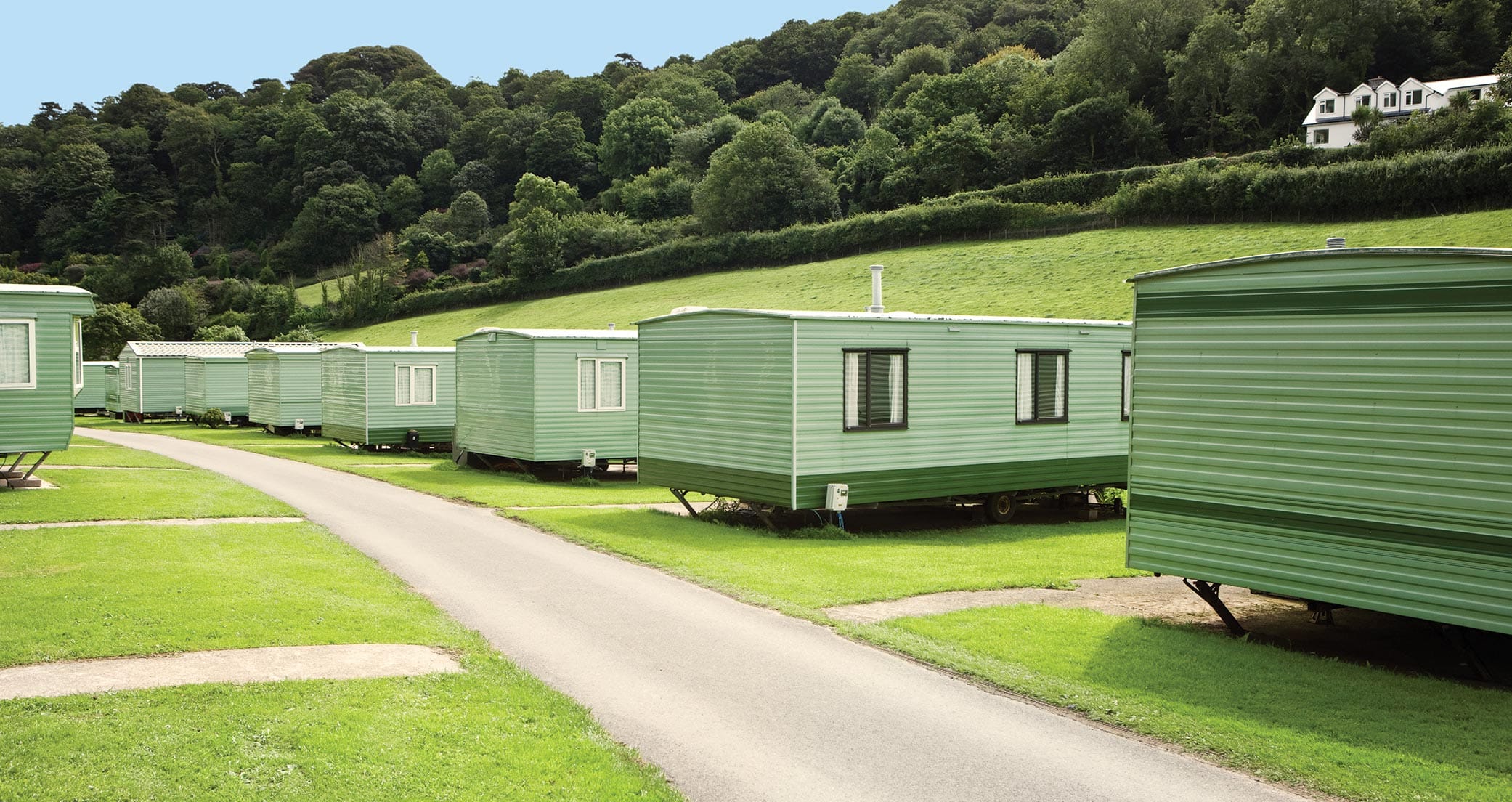 A row of mobile homes on a grassy knoll made from eco-friendly materials Ideas of Order Magazine