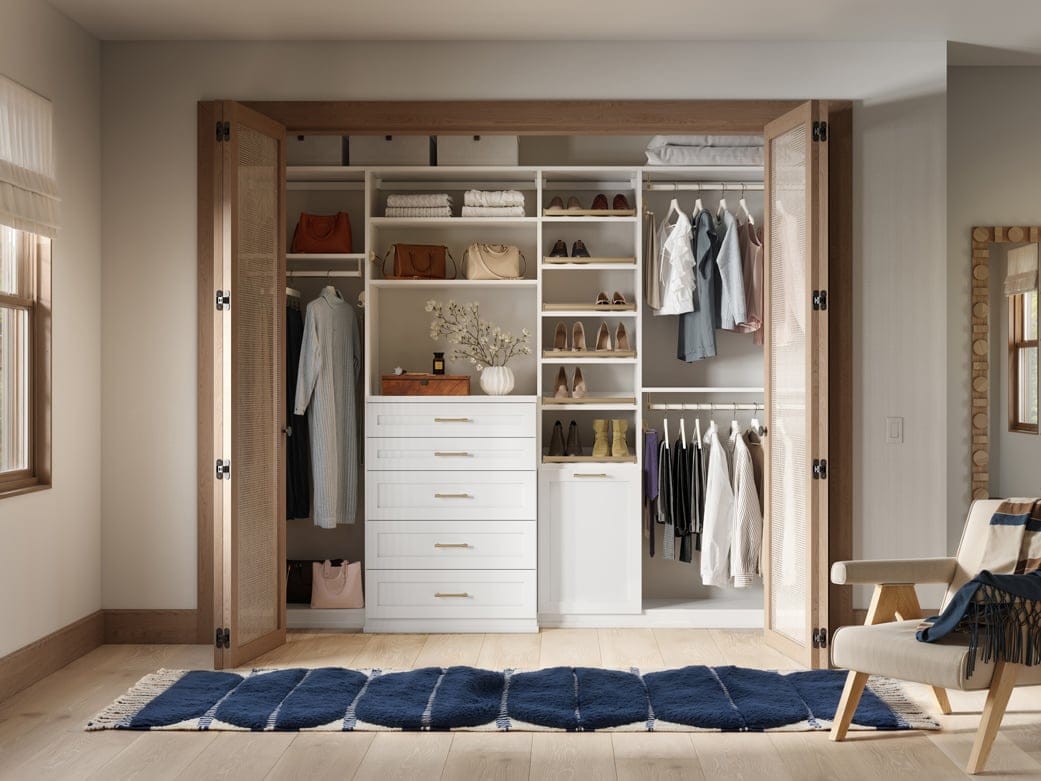 Custom reach in closet design with dresser drawers, cubbies, open shelving in light finish by by California Closets